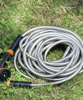 Coiled No Tangle 25ft Stainless Steel Garden Hose With Ten Function Adjustable Spray Nozzle on grass