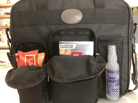 Front view of black New Improved Travel Bag Case for Nespresso Essenza Mini and Pixie with pockets holding items.