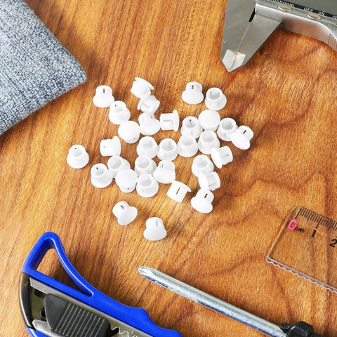 30 Pack 8mm White Plastic Hole Plugs With Snap In Locking End Caps for furniture, visible on a wooden table with tools.