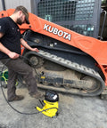 Mechanic using Heavy Duty Grease Gun With 10,000 Psi Output For Fast No Sweat Lubrication on industrial machinery