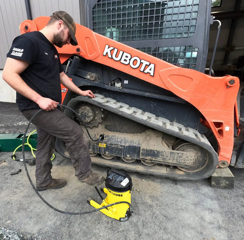 Mechanic using Heavy Duty Grease Gun With 10,000 Psi Output For Fast No Sweat Lubrication on industrial machinery