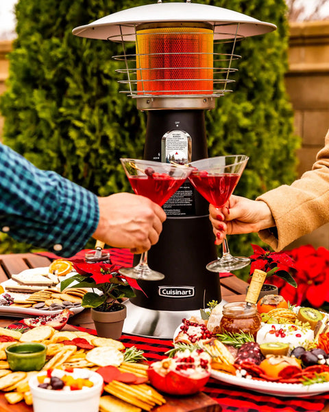 Portable Tabletop Propane Patio Heater With 11,000 BTU Power Adjustable Heat Safety Tilt Switch Burner Screen Guard Heats Up To 30 Sq Ft Black Outdoor Heater For Chill Nights on a dining table with food and drinks.
