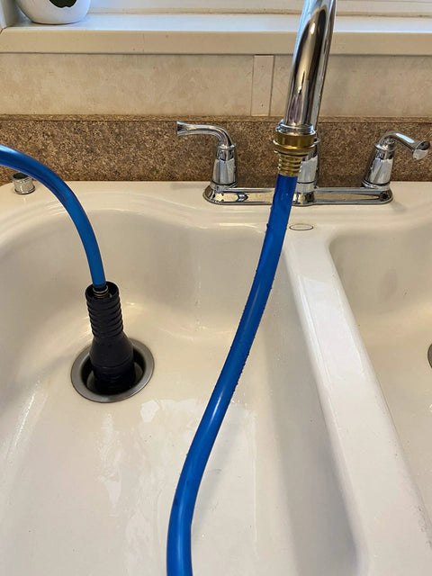 VIP2 Drain Unclogging Kit for 1.5 to 3 inch kitchen drains in use, water-powered cleaner attached to faucet with crossbar adapter.