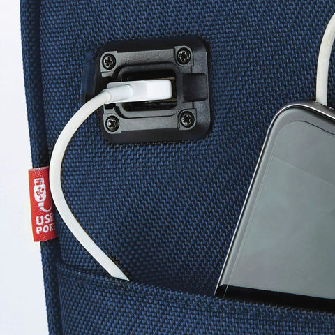 smart underseat carry-on with USB charging port close-up, navy fabric, showing a USB cable connected to a phone in pocket compartment