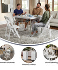 Hercules Series White Padded Folding Chair Set Of 4 used indoors around table with people, 800 lb capacity for home gatherings.
