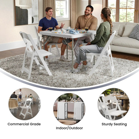 Hercules Series White Padded Folding Chair Set Of 4 used indoors around table with people, 800 lb capacity for home gatherings.
