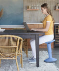 Woman using SitWell Wobble Stool With Adjustable Height For Active Seating In Classrooms And Libraries, powder blue version