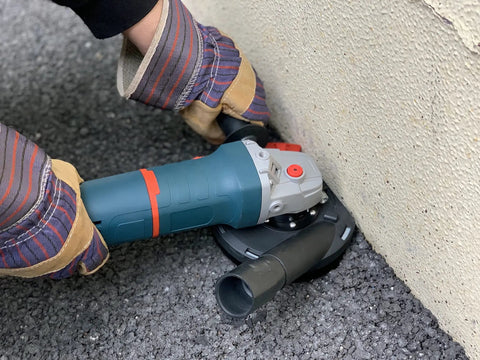 Universal 5 Inch Angle Grinder Slurp Guard Dust Shroud With Quick Clamp Fitting and Shop Vac Hose Adapter for 39 to 51mm Grinders in use on surface.