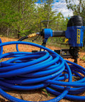 Coiled One Quarter Inch By One Hundred Foot PVC And Rubber Hybrid Air Hose With Brass Fittings, Kink Resistant, in outdoor setting