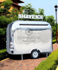 Premium Polished Mirror Food Trailer With Fold Down Awning And Stainless Steel Counter Space For Concession Operators And Mobile Coffee Shops Solid Gear To Crush Sales Daily, shiny exterior with 'SHAVE ICE' sign.