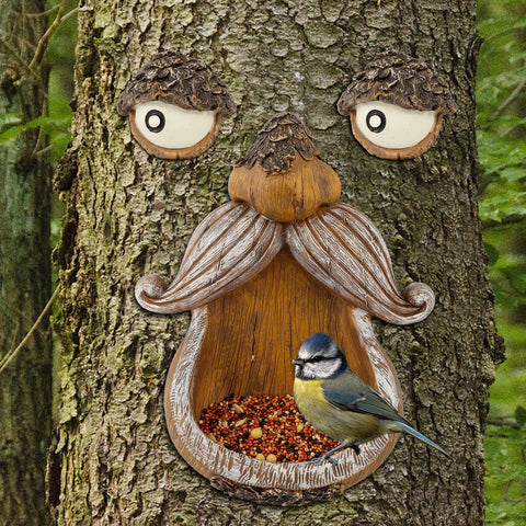 Tree Face Bird Feeder Outdoor Decor With Glow In The Dark Eyes Old Man Tree Hugger Sculpture Dope Yard Art Garden Ornament For Birds And Birdwatchers Perfect For Gardens And Lawns installed on a tree with a bird in the seed dispenser.