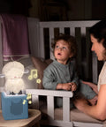 Night Light For Kids Sleep Aid With Sleepy Sheep Audio Play Character emitting glow on bedside in child's room with parent.