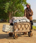 Woman pulling a Heavy Duty Collapsible Folding Wagon With Integrated Aluminum Table All Terrain Beach Cart with camping gear in khaki