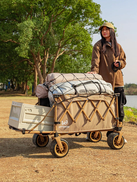 Woman pulling a Heavy Duty Collapsible Folding Wagon With Integrated Aluminum Table All Terrain Beach Cart with camping gear in khaki