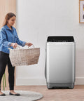 Lowkey Quiet Portable Washing Machine Full Automatic 2.0 Cubic Foot Compact Washer Grey next to woman carrying laundry basket.