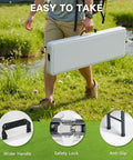 Person carrying heavy duty folding bench for outdoor use with 770 pound capacity, safety lock button, wide carry handle
