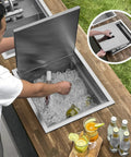 Badass Hella Insulated Workstation Sink For Outdoor Kitchen Bar Station With Deep Stainless Bowl Includes Heavy Duty Lid Commercial Grade Strainer And Cutting Board Built Sick, shown with ice and drinks.