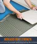 Person installing tile over Solid Uncoupling Membrane Roll For Tile Underlayment Spanning 150 Square Feet to ensure stability.