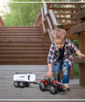Child playing with Friction Powered Farm Tractor Trailer Toy Set 16 Inch Three Pack For Kids with red water tank trailer outdoors.