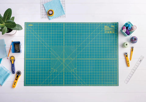 24 By 36 Inch Self Healing Rotary Cutting Mat Double Sided With Grids For Quilting Sewing Fabric Crafts on a craft table