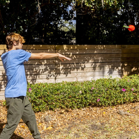 Child playing outdoors with Vortex Aero Howler Foam Football With Mega Distance Passes Flight Tail For Long Throws Whistling Roar In Flight Indoor Outdoor Fun For Kids Easy Grip Foam Ball Stocking Stuffer And Birthday Gift