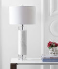 32 Inch White Marble And Crystal LED Table Lamp With Linen Shade on a desk next to books and a vase, for living room or bedroom.
