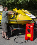 User refueling a yellow jet ski with Duramax Flo N Go 14 Gallon Gas Caddy On Wheels With 10 Foot Hose And Portable Fuel Tank Transfer Pump