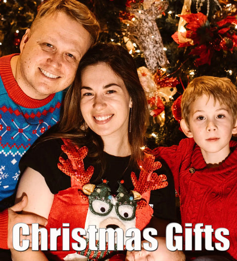 Family portrait celebrating Christmas with gifts, dressed in festive attire and surrounded by holiday decorations.