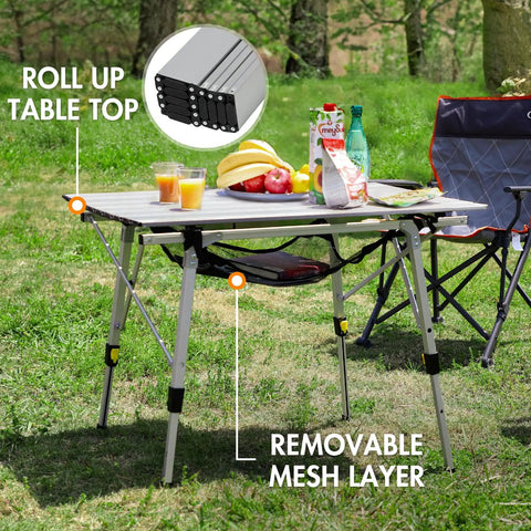 Foldable Outdoor Picnic Camping Table With Adjustable Height Aluminum Legs And Roll Up Top in a backyard setup.