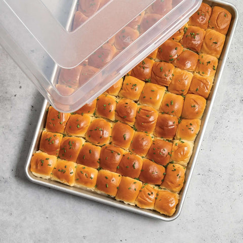 Extra Large High Sided Baking Pan With Lid For Big Batches Uncoated Aluminum Sheet Pan Reinforced Steel Rim Prevents Warping shown with rolls