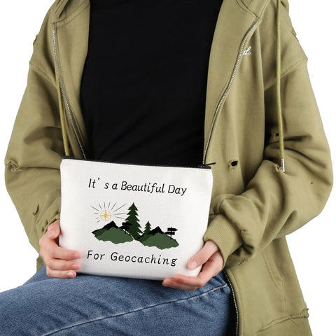 Person holding a Geocaching Makeup Bag For Outdoor Lovers It Is A Beautiful Day For Geocaching Gift Beige Durable Canvas Zip Bag