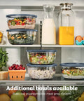 5 In 1 Kitchen Prep And Storage Bowl System Featuring Crinkle Slice And Shred Blades For Real Deal Meal Prep And Hosting Like A Champ With Secure Snap Lids in refrigerator with various salads and fruits.
