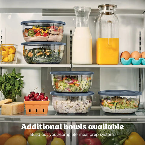 5 In 1 Kitchen Prep And Storage Bowl System Featuring Crinkle Slice And Shred Blades For Real Deal Meal Prep And Hosting Like A Champ With Secure Snap Lids in refrigerator with various salads and fruits.