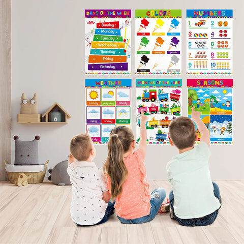 Children looking at 17 Poster Set For Early Education With Alphabet Numbers Time Shapes Seasons Months Emotions Weather Money Colors Opposites Five Senses Math Solar System Farm Animals On Durable PET Film Covers For Nursery And Kindergarten on a wall.