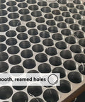 Annular cutter: top-down view of a metal sheet with uniform 5/8 in holes and smooth reamed edges