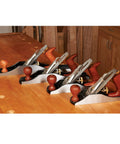Heirloom Grade Bench Plane Set Featuring Number Three Four Five And Six Hand Tools on a workbench with ergonomic handles.