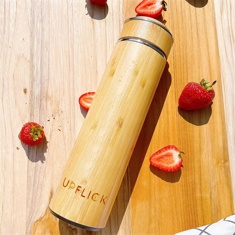 Premium 17 Oz Bamboo Tea Tumbler With Removable Loose Leaf Infuser double wall, bamboo material, surrounded by strawberries.