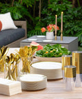 Heavy Duty White Plastic Plates With Gold Trim 175 Piece Bulk Party Essentials arranged on a table with utensils and decor.