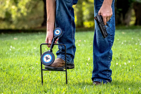 Man setting up Beefy Handgun Rebar Spinner Steel Target For 9mm Through .45 Caliber Pistols, 3/8 Inch Steel With Powder Coat outdoors.