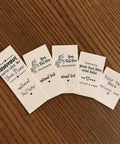 Next Level Custom Cotton Tags Straight Up Premium Fabric Sewing Labels For Quilting Knitting Handmade Clothing Branding Markers Machine Washable Care Instructions 40X50Mm on wooden surface.
