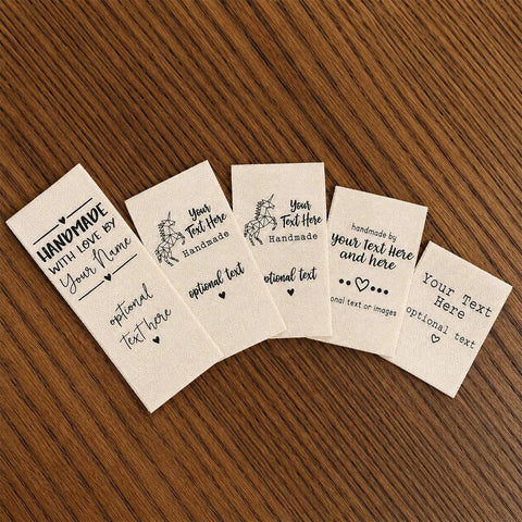 Next Level Custom Cotton Tags Straight Up Premium Fabric Sewing Labels For Quilting Knitting Handmade Clothing Branding Markers Machine Washable Care Instructions 40X50Mm on wooden surface.