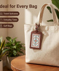 Four Pack No Fuss Needlepoint Luggage Tags Featuring Slick Faux Leather Shell And Crystal Clear Id Window on a tote bag.