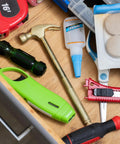 GreatNeck 5-in-1 hammer in a cluttered tool drawer with glue, tape measure, screwdrivers, and utility knives.
