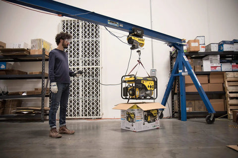 Person using heavy duty electric hoist with remote control and automatic braking 850 watt motor in garage workshop