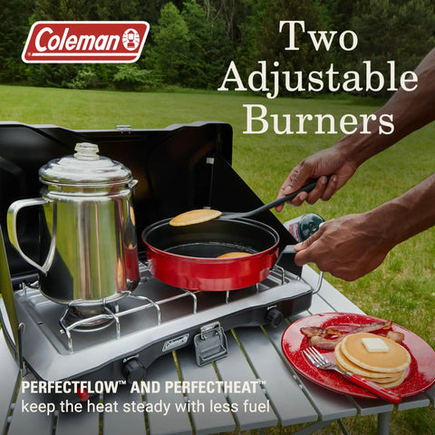 Two-Burner Propane Camp Stove With InstaStart Ignition And Wind Guards in use, cooking pancakes in the outdoors.