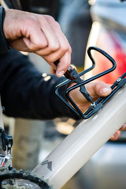 Using 8 In 1 EDC Multitool Pocket Knife with quarter inch bit driver on a bicycle, burnt orange handle visible