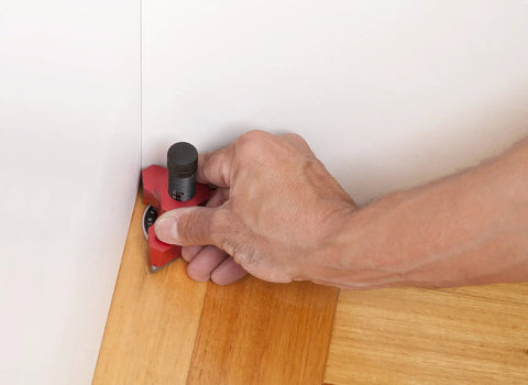 Person using Heavy Duty Tungsten Carbide Scribing Tool Imperial Metric Gauge for precise laminate trim work in a corner.