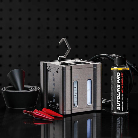 Ventus smoke tester in a metal case with gauge windows and a top hook, beside an Autoline Pro bottle and red test tips.