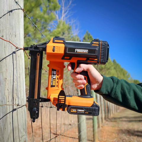 Hardcore 20V Cordless Fencing Stapler Kit Bundled With 16 Gauge 1 Inch Staples And Rock Solid 2AH Battery Plus Fast Charger And Roomy Tool Bag For Roughneck Builders in action on a fence post.