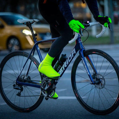 Cyclist wearing Arctic Waterproof Deep Winter Road Bike Overshoes for Road Shoes, neon green color for visibility
